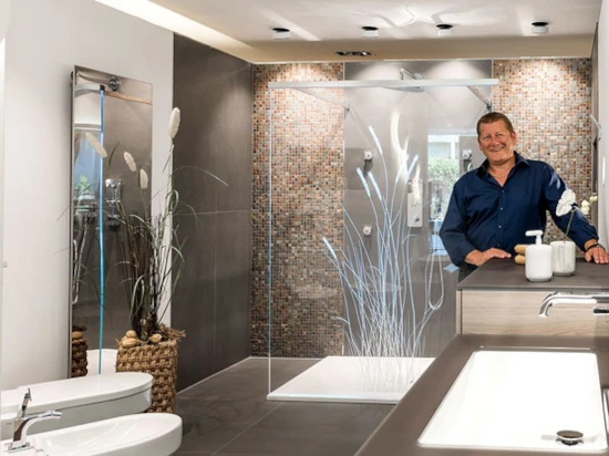 Modernes Badezimmer mit begehbarer Dusche, stilvollen Fliesen und freundlichem Mann.